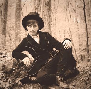 Portrait of young woman sitting in forest