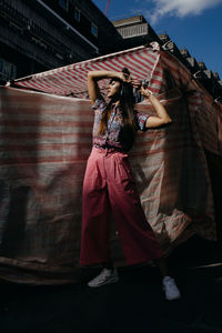 Full length of woman standing against built structure