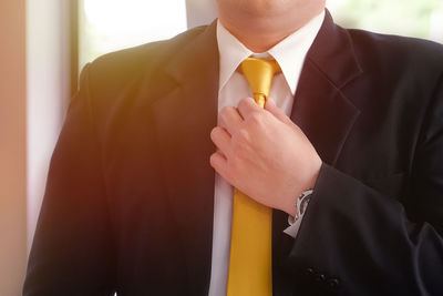 Midsection of businessman wearing suit standing at home