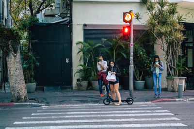 People riding bicycle on street in city