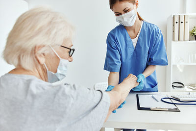 Side view of doctor examining patient at clinic