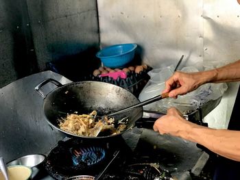 Midsection of man cooking food in kitchen