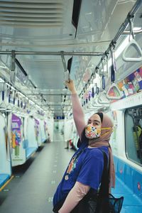 Rear view of woman standing by train