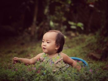 Cute baby girl playing amidst plants at public park