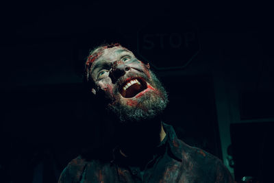 Portrait of man wearing mask against black background