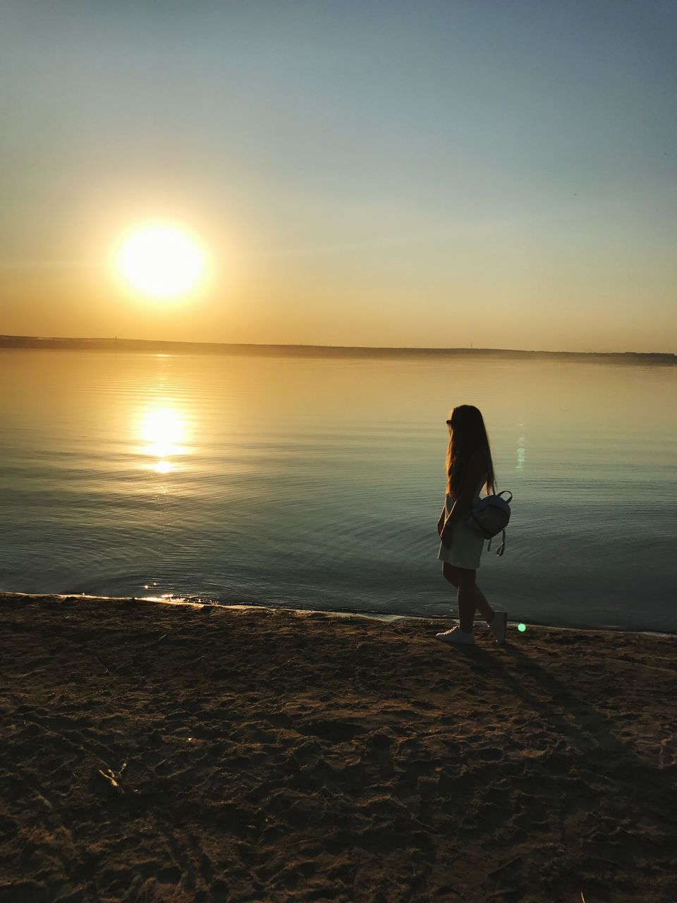 sunset, beach, nature, reflection, water, sea, sun, beauty in nature, scenics, full length, one person, tranquility, tranquil scene, sand, sky, standing, sunlight, horizon over water, leisure activity, real people, side view, silhouette, outdoors, lifestyles, women, young adult, day, people