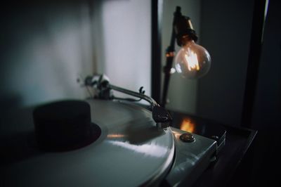 Close-up of illuminated light bulb by turntable