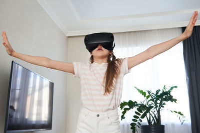 Girl wearing virtual reality simulator at home