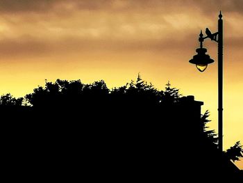 Low angle view of silhouette street light against sky at sunset