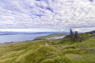 Scenic view of landscape by sea against sky