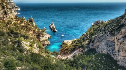 High angle view of cliff by sea against sky