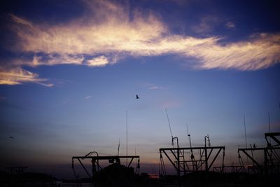 Silhouette birds flying against sky during sunset