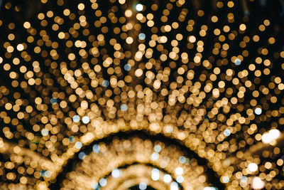 Christmas background design with golden glowing bokeh ligts, festive abstract confetti. 