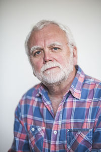 Portrait of senior therapist against white wall at home office