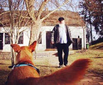 Man with dog standing in front of building