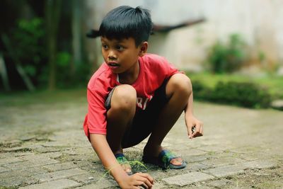 Side view of young man sitting on field