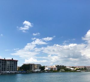Sea by buildings against sky