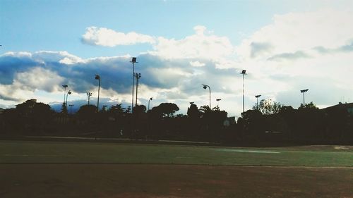 Road by trees against sky