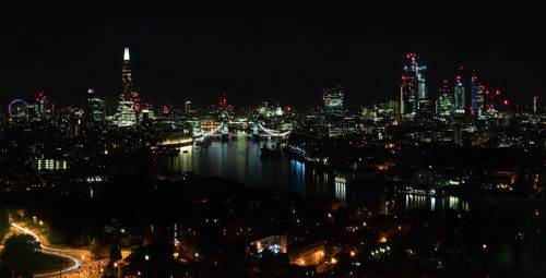 Illuminated buildings in city against sky at night