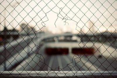 Close-up of hole in chainlink fence