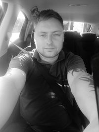 Portrait of young man sitting in car