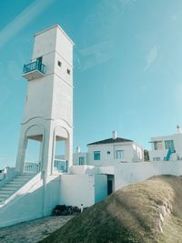 View of white building by sea against sky