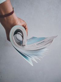High angle view of hand holding paper over white background