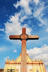 Low angle view of cross on building against sky