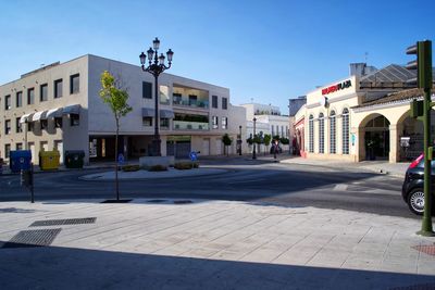 City street by buildings against sky