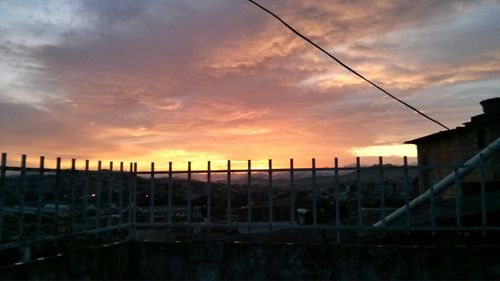 Fence against sky during sunset