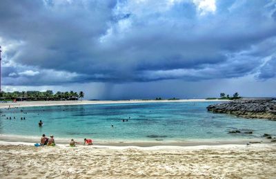 People on beach against sky