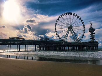 Ferris wheel at beach against sky