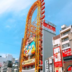 Low angle view of ferris wheel against buildings in city