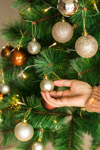 Woman hand holding bauble for christmas tree. merry christmas and happy new year 2021