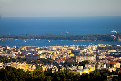 High angle view of townscape by sea against sky