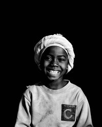 Portrait of young woman against black background