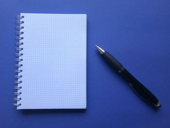 High angle view of pen on table against blue background