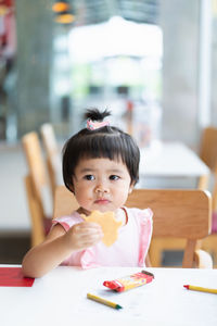 Cute boy eating food at home