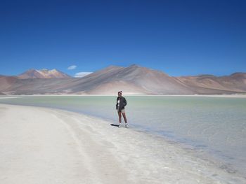 Rear view of man on desert against clear sky