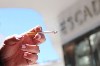 Close-up of hand holding cigarette