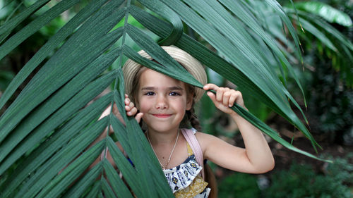 Girl holding leaf in forest