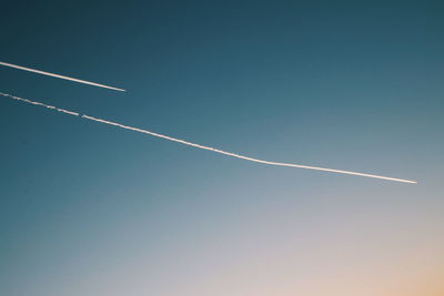 Low angle view of vapor trail against clear blue sky