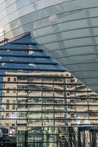 Low angle view of glass building against sky