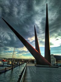 View of boats in city against cloudy sky