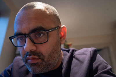 Close-up of man wearing eyeglasses at home