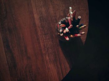High angle view of pencils in desk organizer on wooden table