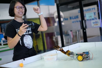 Girl playing game while clenching fist at table