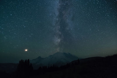 Scenic view of silhouette mountains against star field at night