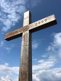 Low angle view of cross sign against sky