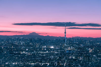 Illuminated buildings in city during sunset